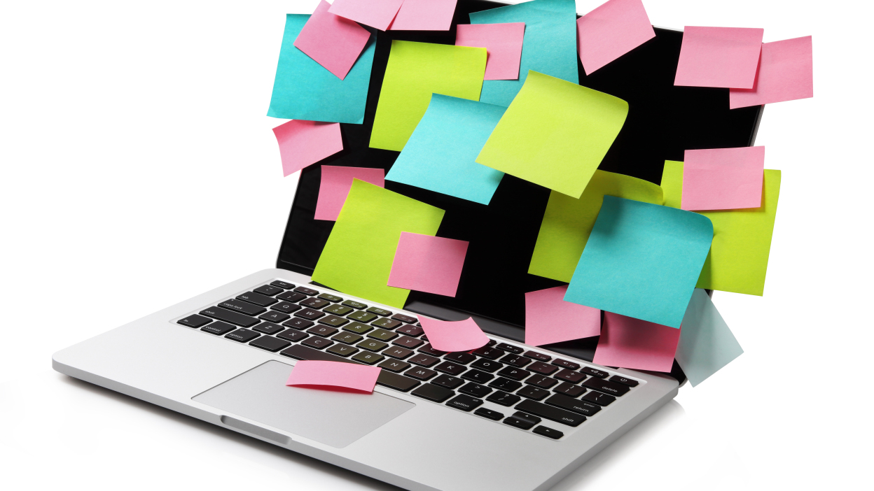 A MacBook covered in sticky notes. 