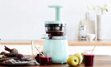 Mint colored juicer making a dark colored beet juice