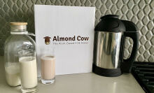 Almond cow nut milk maker next to a jug and two glasses of alternative milk