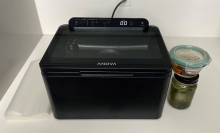 large vacuum sealer on kitchen counter with jars and sealing bags