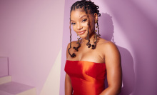 Halle Bailey wearing a red dress in front of a pink background