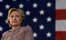 Former presidential candidate Hillary Clinton stands before an American flag, during her campaign in 2016.