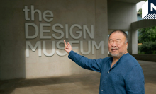 Ai Weiwei faces the camera as he flips a middle finger in front of London's Design Museum in reference to his famous photographs.