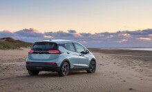 The 2022 Chevrolet Bolt EV, parked on a beach as the sun sets.