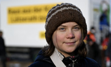 Thunberg stares into the camera wearing a brown beanie.