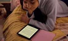 person reading kindle paperwhite kids on their bed
