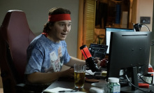 Paul Dano as RoaringKitty, a young white man in front of a home computer and microphone setup.