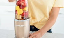 person holding the nutribullet pro filled with fruit