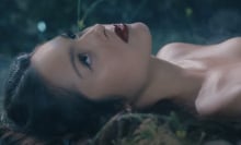 Olivia Rodrigo lies on the grass in her music video "vampire."