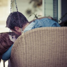 Back view of two people with heads together in hanging loveseat
