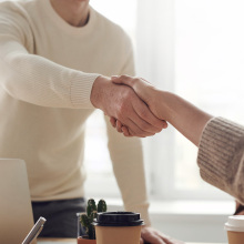 two people shaking hands over a table