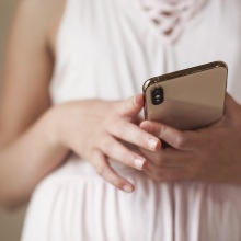 A girl holds a smartphone in her hand. 