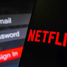 The Netflix logo is displayed on a smartphone screen, next to a login screen, with email, password, and sign in. 