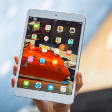 iPad mini 2 being held up in someone's hand.