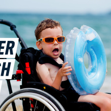 An excited young boy in a wheelchair holds an inflatable life belt. Caption reads: "Easier beach days"