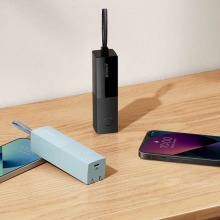 Anker 511 Power Banks in two different colors shown next to two phones lying on a table