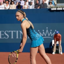 A tennis player serves on a Grand Slam court.