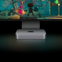 The Apple Mac mini resting below a larger Apple-brand monitor