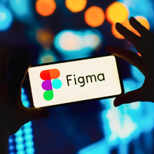 A pair of hands holding a phone with the Figma logo.
