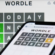 Wordle game displayed on a phone and a laptop screen