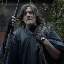Norman Reedus as Daryl from "The Walking Dead" in a poncho holding a spear.