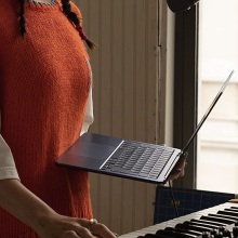 person holding 2022 m2 macbook air in front of a piano
