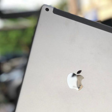 the Apple iPad 6th-gen shown in a light grey color on a blurred background 