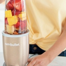 person holding the nutribullet pro filled with fruit
