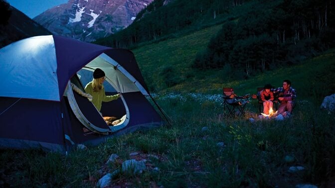 Person coming out of a tent at dusk