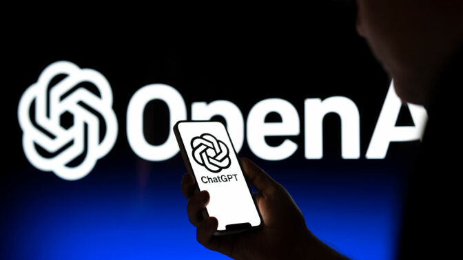 ChatGPT logo on a smartphone in front of a projection of the OpenAI logo