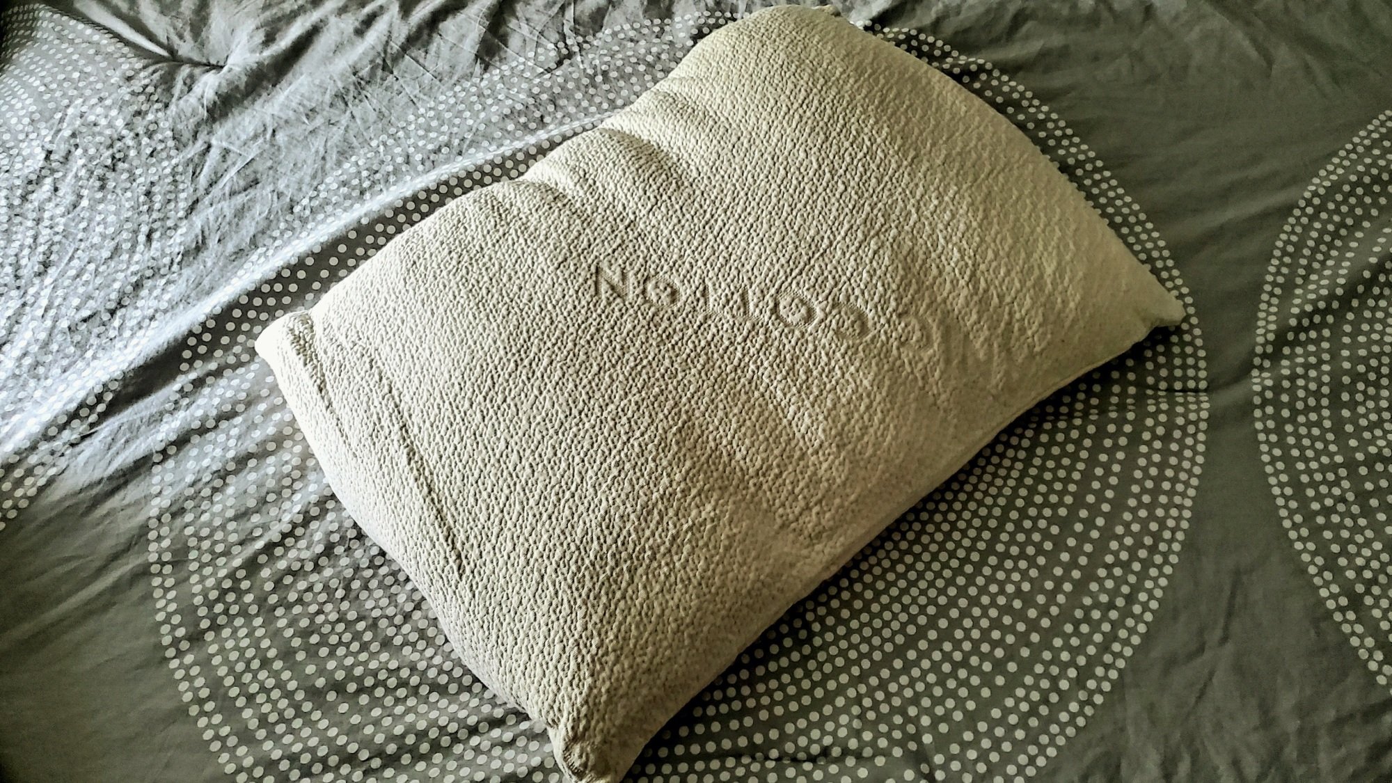 avocado green pillow sitting on top of bed 