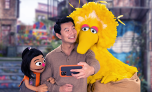 Actor Simu Liu welcomes new muppet Ji-Young to the neighborhood on Sesame Street with Big Bird.