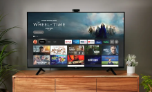 Amazon Omni TV on TV stand with streaming apps on screen