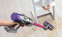 Woman using Dyson V10 to clean up a mess on a hardwood floor