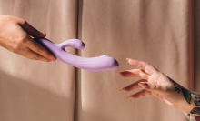 Two people's hands reaching for a vibrator 