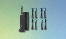 electric toothbrush with extra brush heads and blue and green gradient background