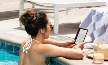 woman reading on kindle in a pool