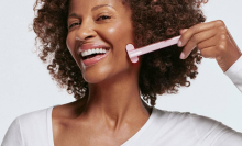 woman smiling and using a solawave skin wand 