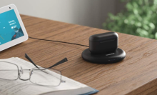 echo earbuds in charging case on a top of a wooden desk