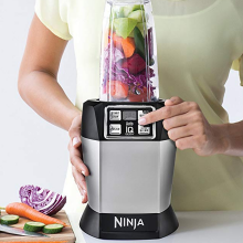 A person pushes a button on a blender