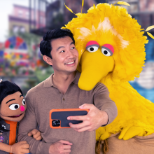 Actor Simu Liu welcomes new muppet Ji-Young to the neighborhood on Sesame Street with Big Bird.