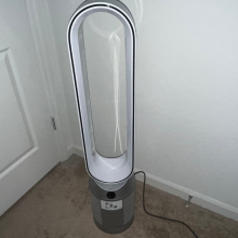 white and silver oblong dyson fan sitting in corner of a room