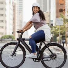 woman riding bird bike through city streets