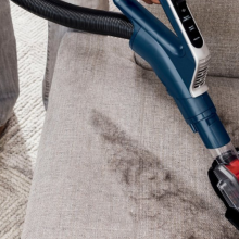close up of person vacuuming couch cushion with shark stratos vacuum