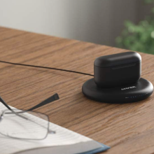 echo earbuds in charging case on a top of a wooden desk