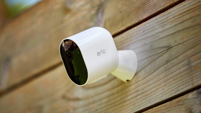 an arlo security camera installed on a wood wall