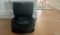 Roomba on hardwood floor with hallway and table in background